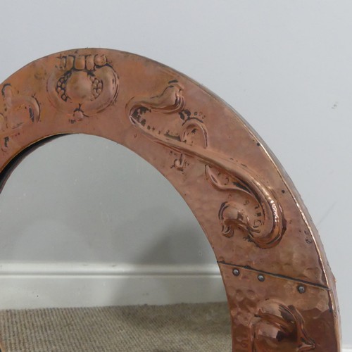 526 - In the manner of Liberty & Co an Arts and Crafts circular copper Mirror, the studded and hammere... 