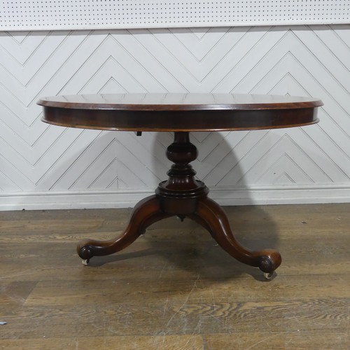 565 - A 19th century mahogany circular breakfast Table, raised on a turned column and three scrolled suppo... 