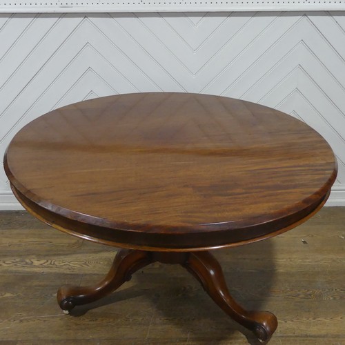 565 - A 19th century mahogany circular breakfast Table, raised on a turned column and three scrolled suppo... 