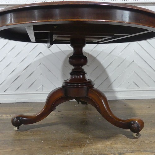 565 - A 19th century mahogany circular breakfast Table, raised on a turned column and three scrolled suppo... 