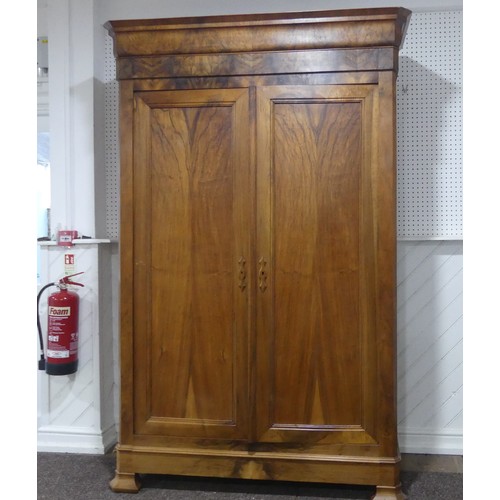 559 - A late 19th century walnut Armoire/Wardrobe, moulded cornice over two large paneled doors, raised on... 