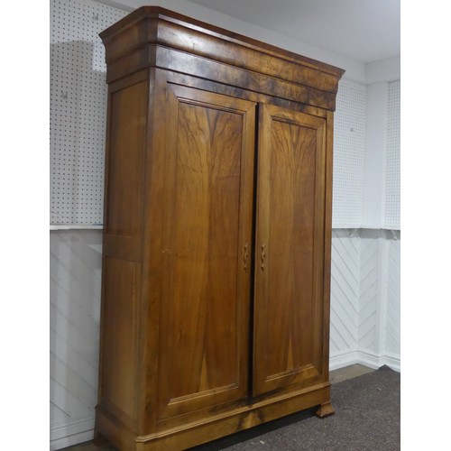 559 - A late 19th century walnut Armoire/Wardrobe, moulded cornice over two large paneled doors, raised on... 