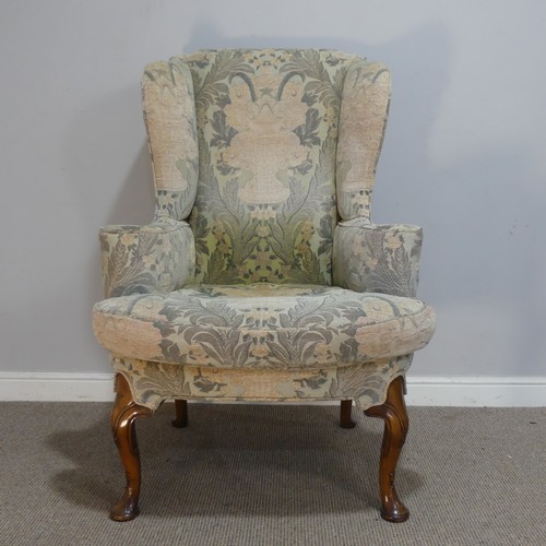 587 - A George II style upholstered wing Armchair, the shaped top over seat, flanked by scrolled arms, rai... 