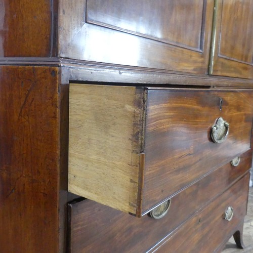 585 - A Regency mahogany Linen Press, the upper section with moulded cornice over paneled doors, concealin... 