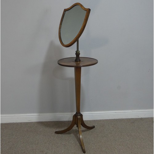 629 - A Georgian mahogany Shaving Stand, the shield swing mirror on telescopic stand, raised on tripod tab... 