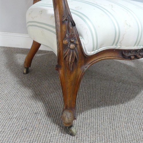 616 - A mid-Victorian carved walnut upholstered Armchair, raised on carved cariole supports, W 66 cm x H 9... 