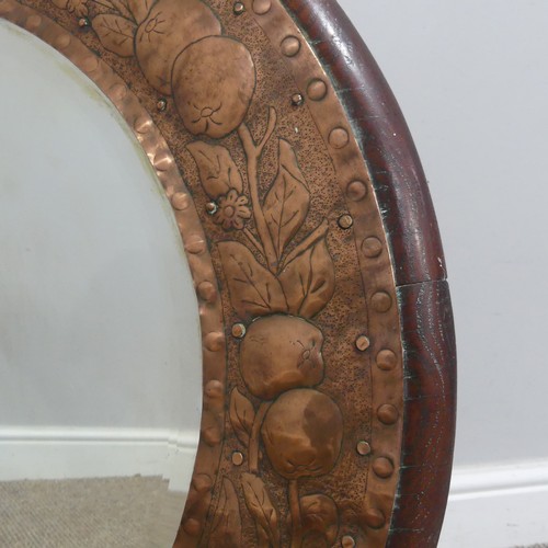 564 - An Arts and Crafts circular oak and copper Mirror, in the manner of Keswick School of Industrial Art... 