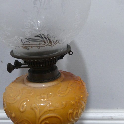 682 - An Art Nouveau Oil Lamp, with orange glass reservoir decorated with stylised flowers, complete with ... 