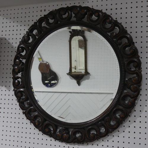 671 - An antique carved oak circular wall Mirror, the carved scrolled frame encasing beveled mirror, W 70 ... 