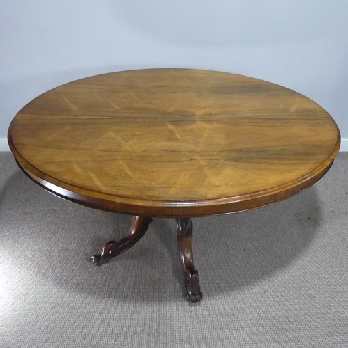 688 - A Victorian rosewood tilt-top Table, the oval top raised on carved and turned column and quadraform ... 