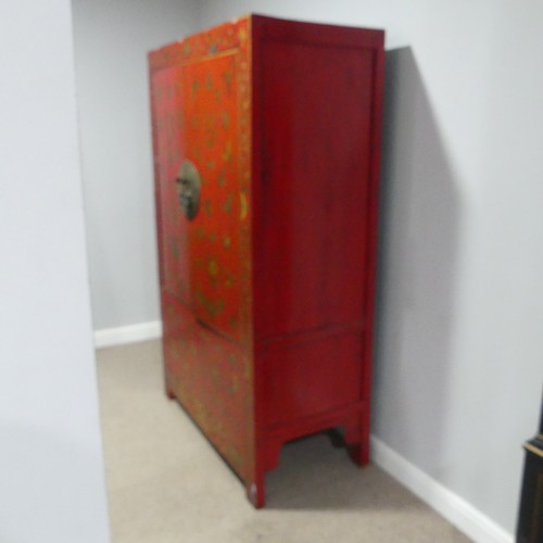 702 - An antique Chinese red-lacquered Cabinet, with two cupboard doors and hinged top compartment, decora... 