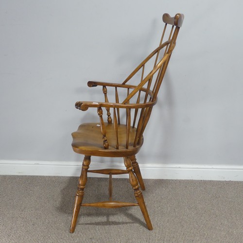 700 - A 20th century ash and elm windsor Armchair, with a shaped comb-back and scrolled arms, raised on sh... 