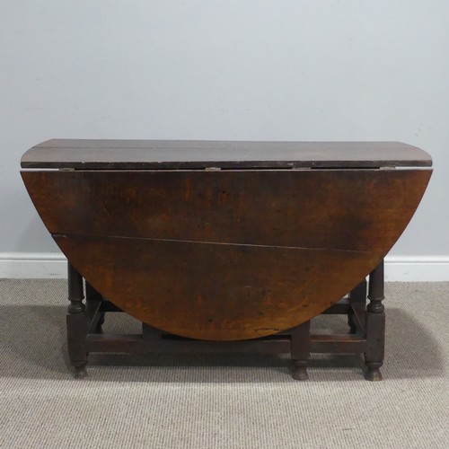 717 - An antique oak gateleg Table, raised on turned supports, W 124 cm x H 69 cm x D 148 cm.... 