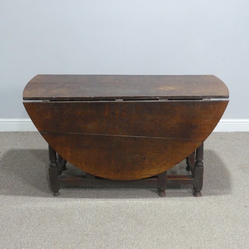 717 - An antique oak gateleg Table, raised on turned supports, W 124 cm x H 69 cm x D 148 cm.... 