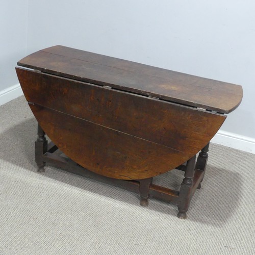 717 - An antique oak gateleg Table, raised on turned supports, W 124 cm x H 69 cm x D 148 cm.... 