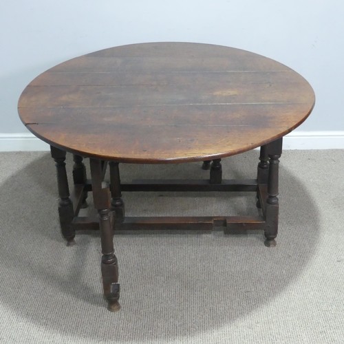 717 - An antique oak gateleg Table, raised on turned supports, W 124 cm x H 69 cm x D 148 cm.... 