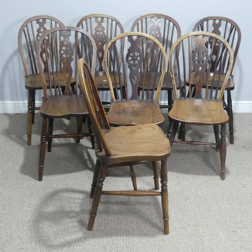 718 - A 19th century harlequin set of eight wheelback dining Chairs, with shaped saddle seats raised on tu... 