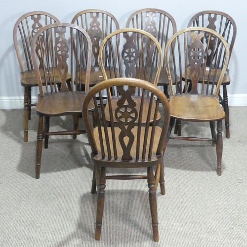 718 - A 19th century harlequin set of eight wheelback dining Chairs, with shaped saddle seats raised on tu... 