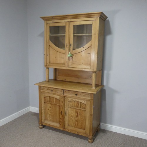 748 - A 20th century pine kitchen Dresser, the moulded cornice over glazed doors and shelves, raised on cu... 