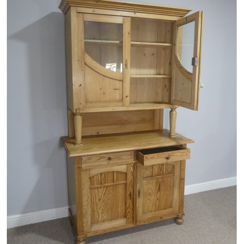 748 - A 20th century pine kitchen Dresser, the moulded cornice over glazed doors and shelves, raised on cu... 