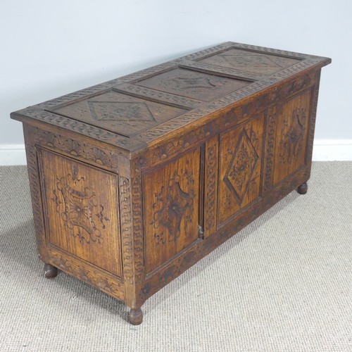 747 - An early 19th century carved oak Coffer, the hinged top over carved paneled sides, raised on turned ... 