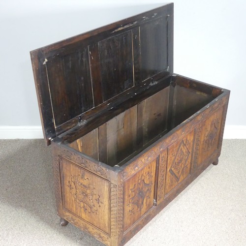 747 - An early 19th century carved oak Coffer, the hinged top over carved paneled sides, raised on turned ... 