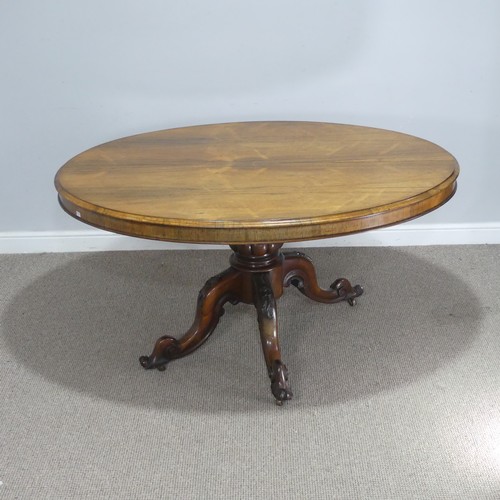 688 - A Victorian rosewood tilt-top Table, the oval top raised on carved and turned column and quadraform ... 