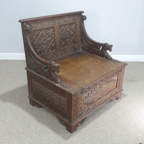 745 - A Victorian carved oak box Seat/Settle, decorated with scrolled pierced foliage and with carved drag... 