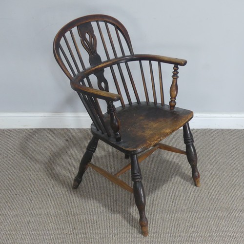 742 - An antique ash and elm Windsor Armchair, with shaped saddle seat raised on turned supports united by... 