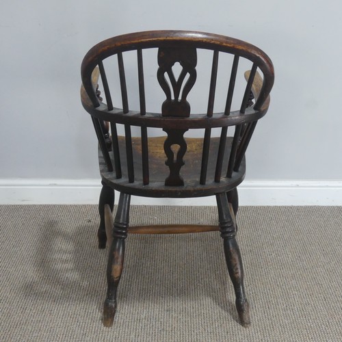 742 - An antique ash and elm Windsor Armchair, with shaped saddle seat raised on turned supports united by... 