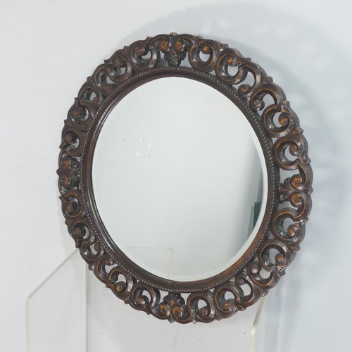 671 - An antique carved oak circular wall Mirror, the carved scrolled frame encasing beveled mirror, W 70 ... 