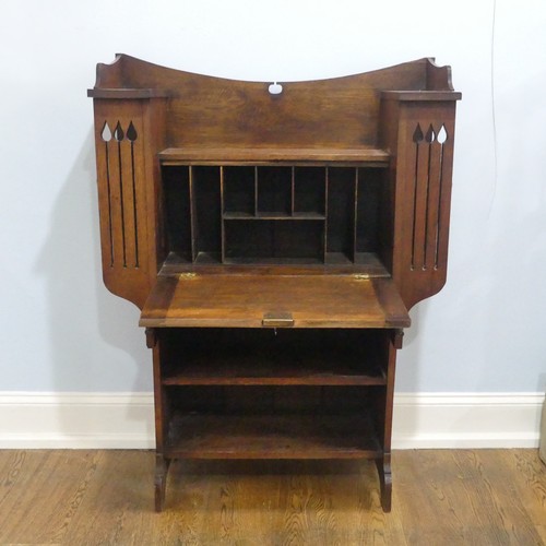 735 - An Arts and Crafts Liberty & co style students desk Bureau, the central fall front flanked by sh... 