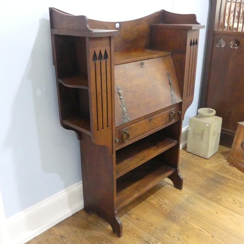 735 - An Arts and Crafts Liberty & co style students desk Bureau, the central fall front flanked by sh... 