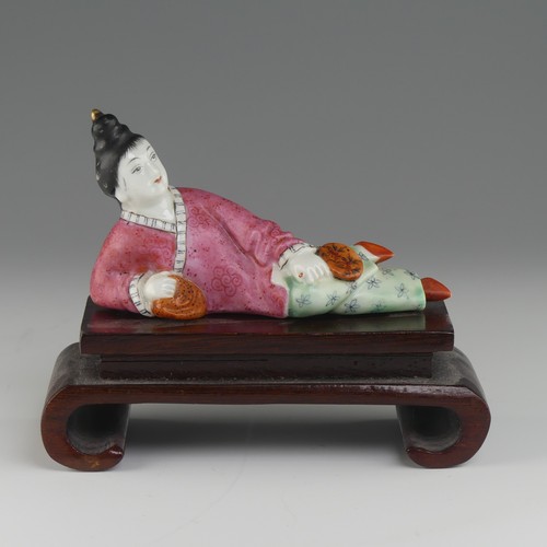 104 - An early 20thC Chinese famille rose porcelain Snuff Bottle, in the form of a recumbent woman with a ... 