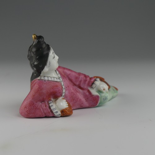 104 - An early 20thC Chinese famille rose porcelain Snuff Bottle, in the form of a recumbent woman with a ... 