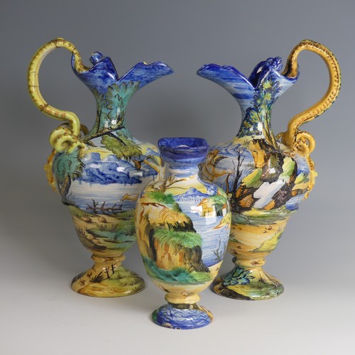 27 - A near matched pair of Italian majolica Ewers, decorated with scenes of cherubs in lakeside mountain... 