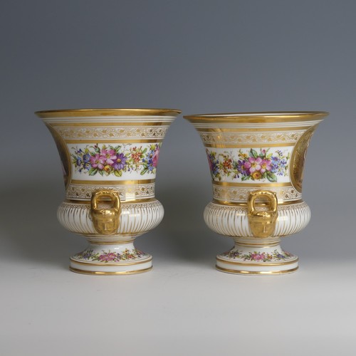 40 - A pair of late 19thC French porcelain Urns, decorated with gilded bands of vines, with central depic... 