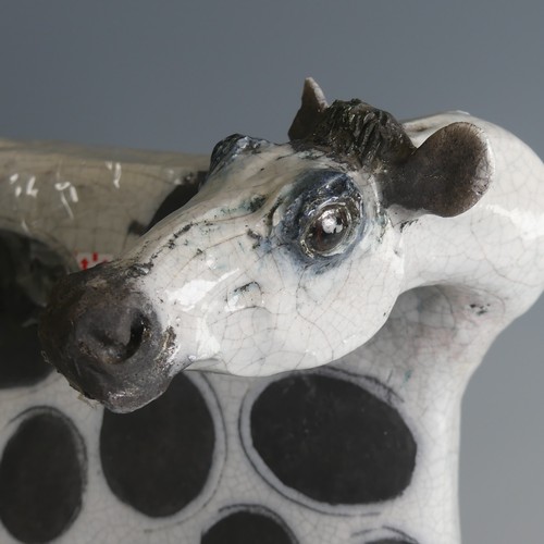 53 - Lawson Rudge (b. 1936) a studio pottery raku Cow, stylised form, decorated with wax resist spots to ... 