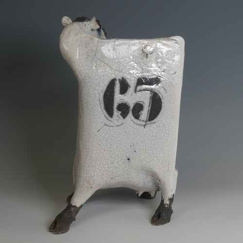 53 - Lawson Rudge (b. 1936) a studio pottery raku Cow, stylised form, decorated with wax resist spots to ... 