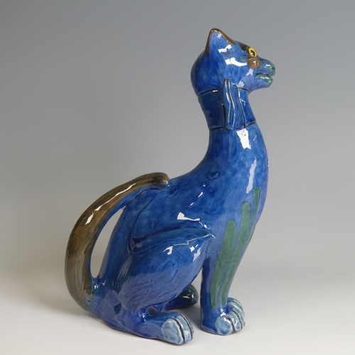 56 - A C. H. Brannam pottery figure of a Cat, with wide grin, sporting a butterfly collar, blue ground pa... 