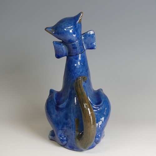 56 - A C. H. Brannam pottery figure of a Cat, with wide grin, sporting a butterfly collar, blue ground pa... 