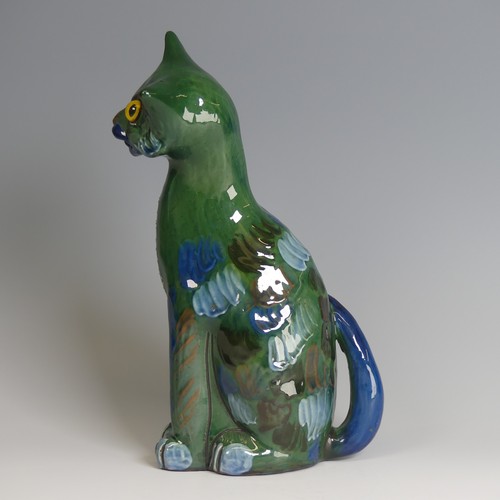 57 - A C. H. Brannam pottery figure of a seated Cat, modelled with cocked head, green ground with blue an... 