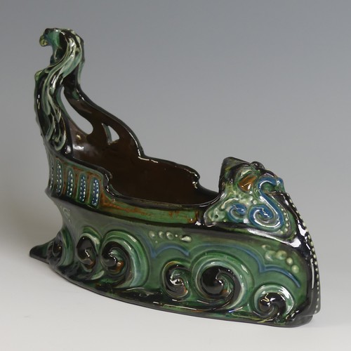 62 - A C. H. Brannam pottery boat shaped flower Trough, with mystical beast figurehead on scrolling waves... 