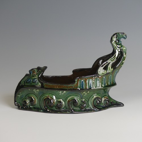 62 - A C. H. Brannam pottery boat shaped flower Trough, with mystical beast figurehead on scrolling waves... 