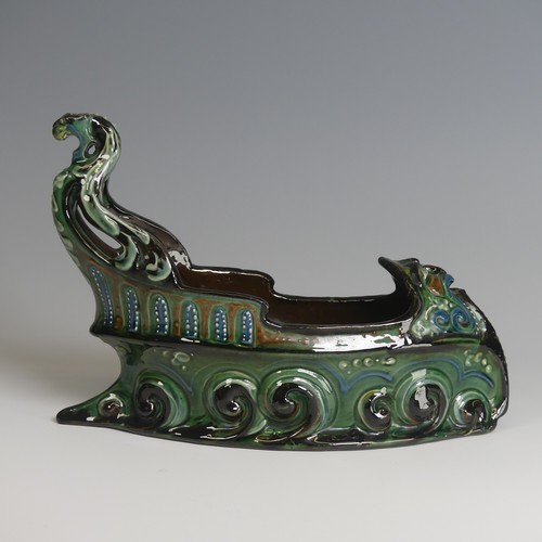 62 - A C. H. Brannam pottery boat shaped flower Trough, with mystical beast figurehead on scrolling waves... 