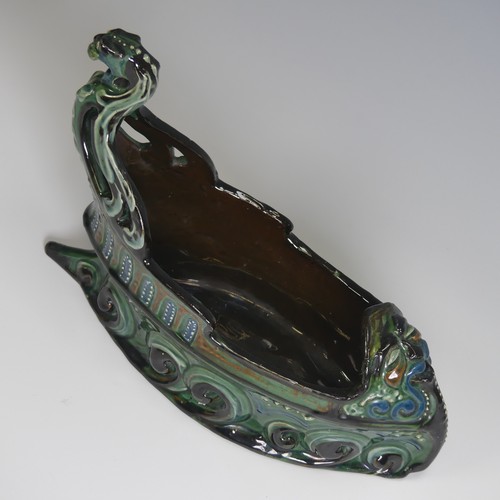 62 - A C. H. Brannam pottery boat shaped flower Trough, with mystical beast figurehead on scrolling waves... 