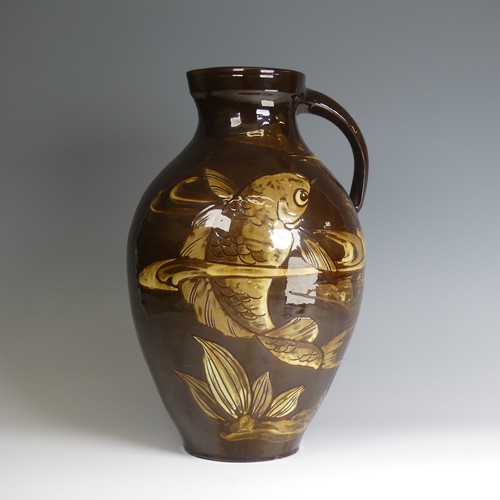 64 - A William Baron for C. H. Brannam pottery Jug, of large size, with dark brown ground decorated in sw... 