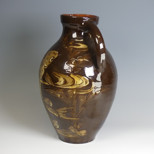 64 - A William Baron for C. H. Brannam pottery Jug, of large size, with dark brown ground decorated in sw... 