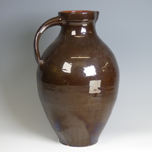 64 - A William Baron for C. H. Brannam pottery Jug, of large size, with dark brown ground decorated in sw... 