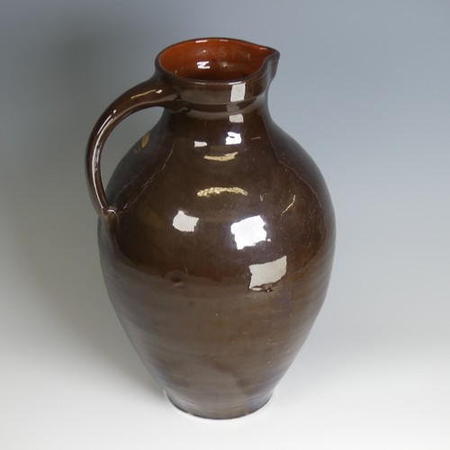 64 - A William Baron for C. H. Brannam pottery Jug, of large size, with dark brown ground decorated in sw... 